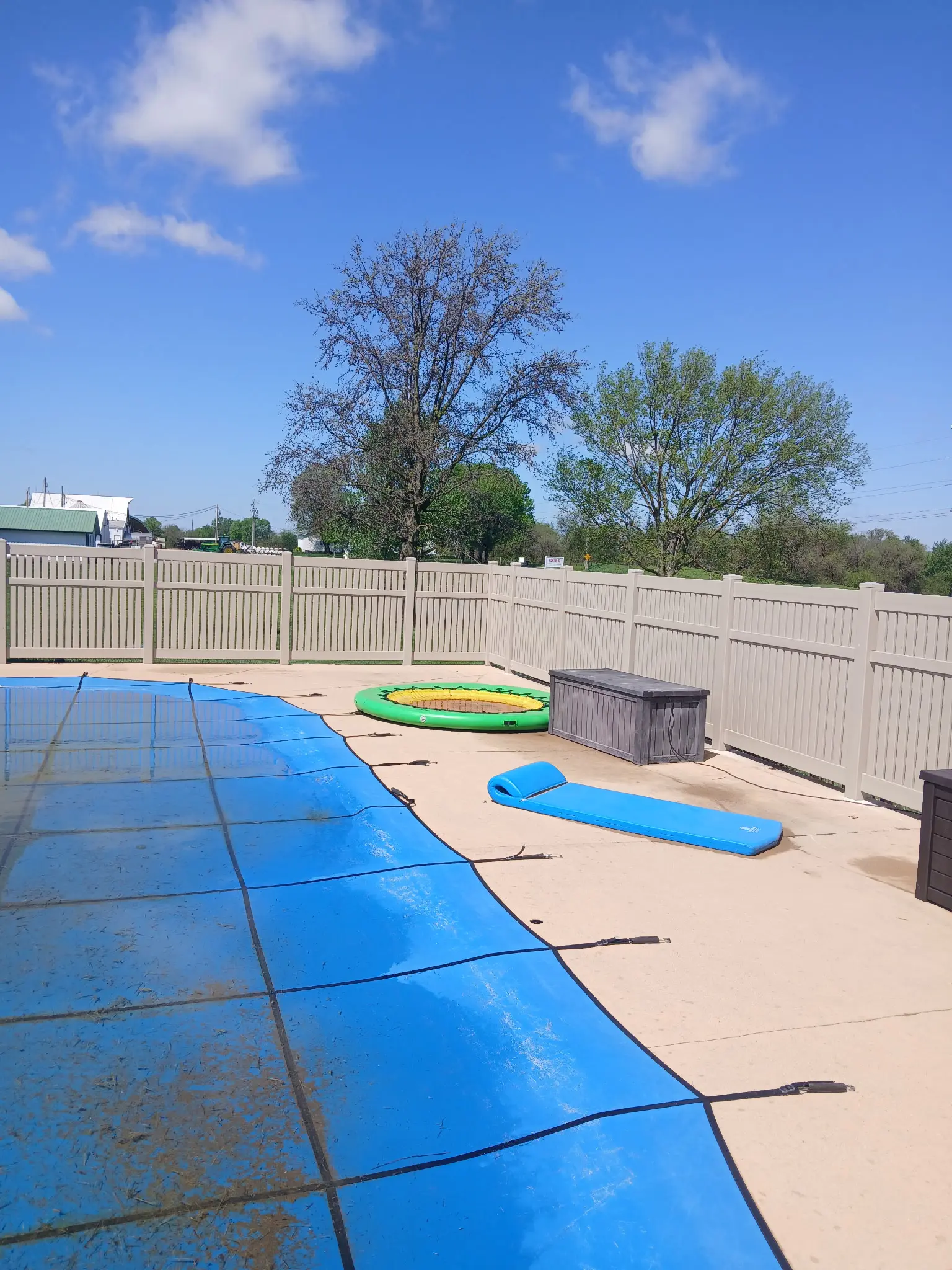 Beige vinyl privacy fence enclosing a swimming pool patio.